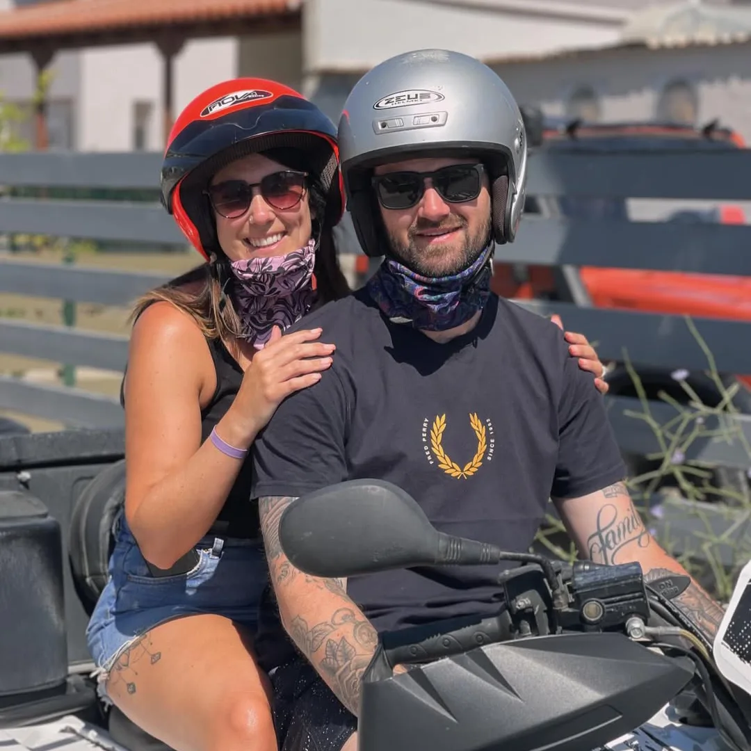 Smiling couple riding an ATV during a sunny day in Kos, Greece