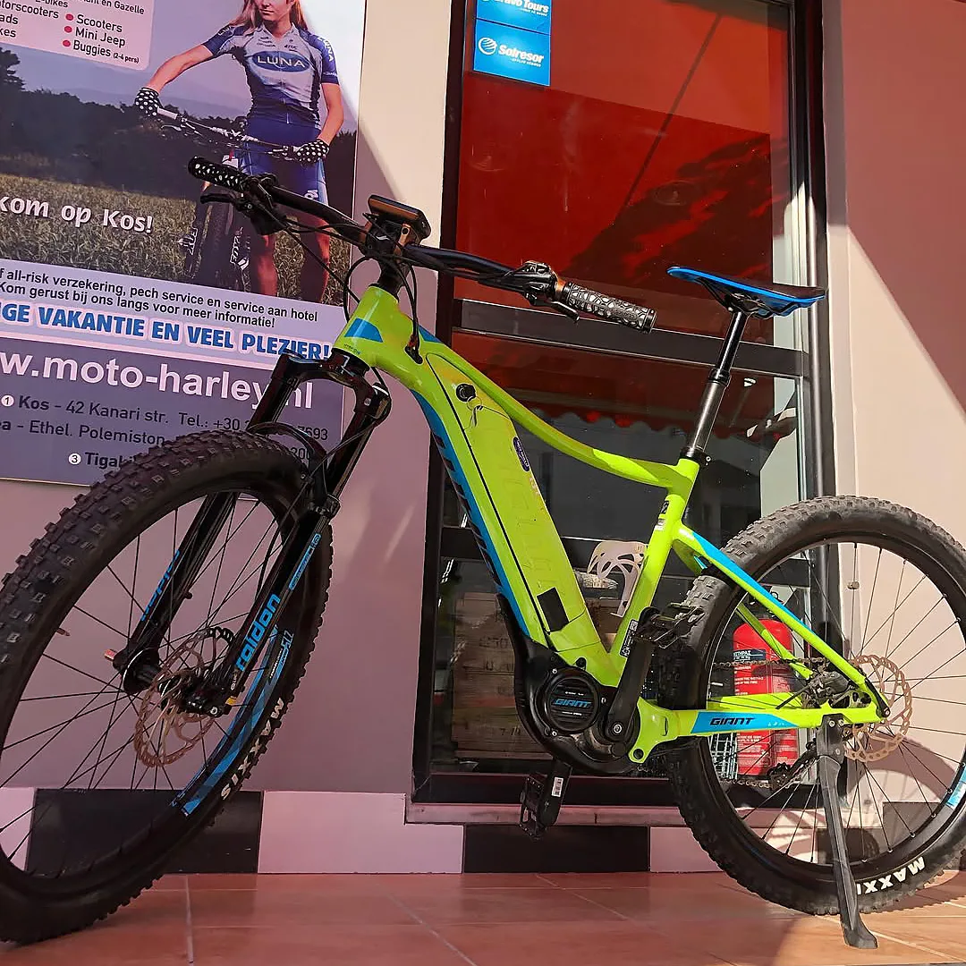 Electric mountain bike parked outside Moto Harley rental shop in Kos